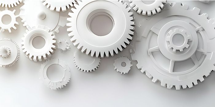 Interlocking white gears on a light background