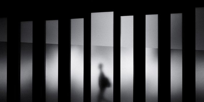 black and white, blurred man walking across different vertical panels thumbnail