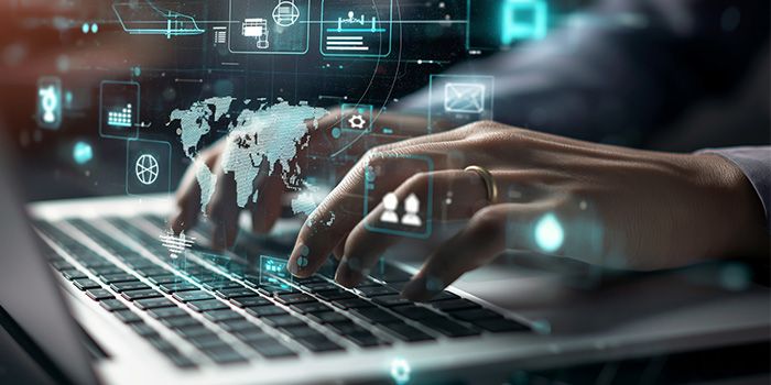 Hands typing on a laptop with overlay of global data analytics icons and graphs.