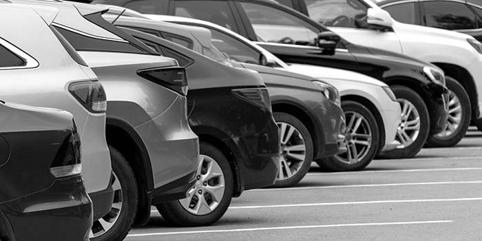 cars lined up in a car park, black and white thumbnail