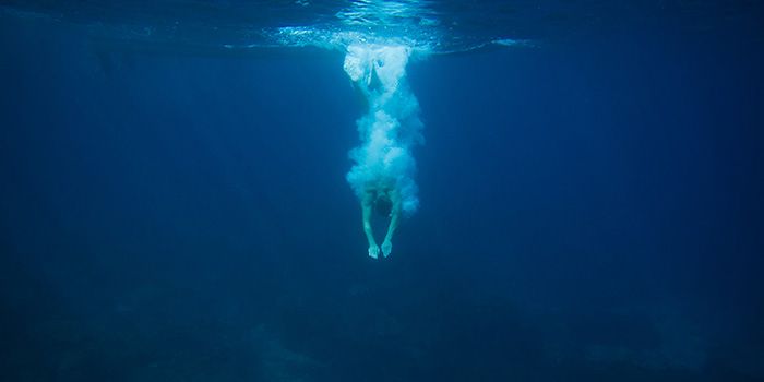 A person diving into deep blue water, symbolising the depth and dynamic nature of programme management.